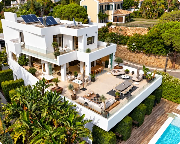 Modern multi-level residential property with solar thermal collectors positioned on its rooftop among landscaped gardens and outdoor living areas.